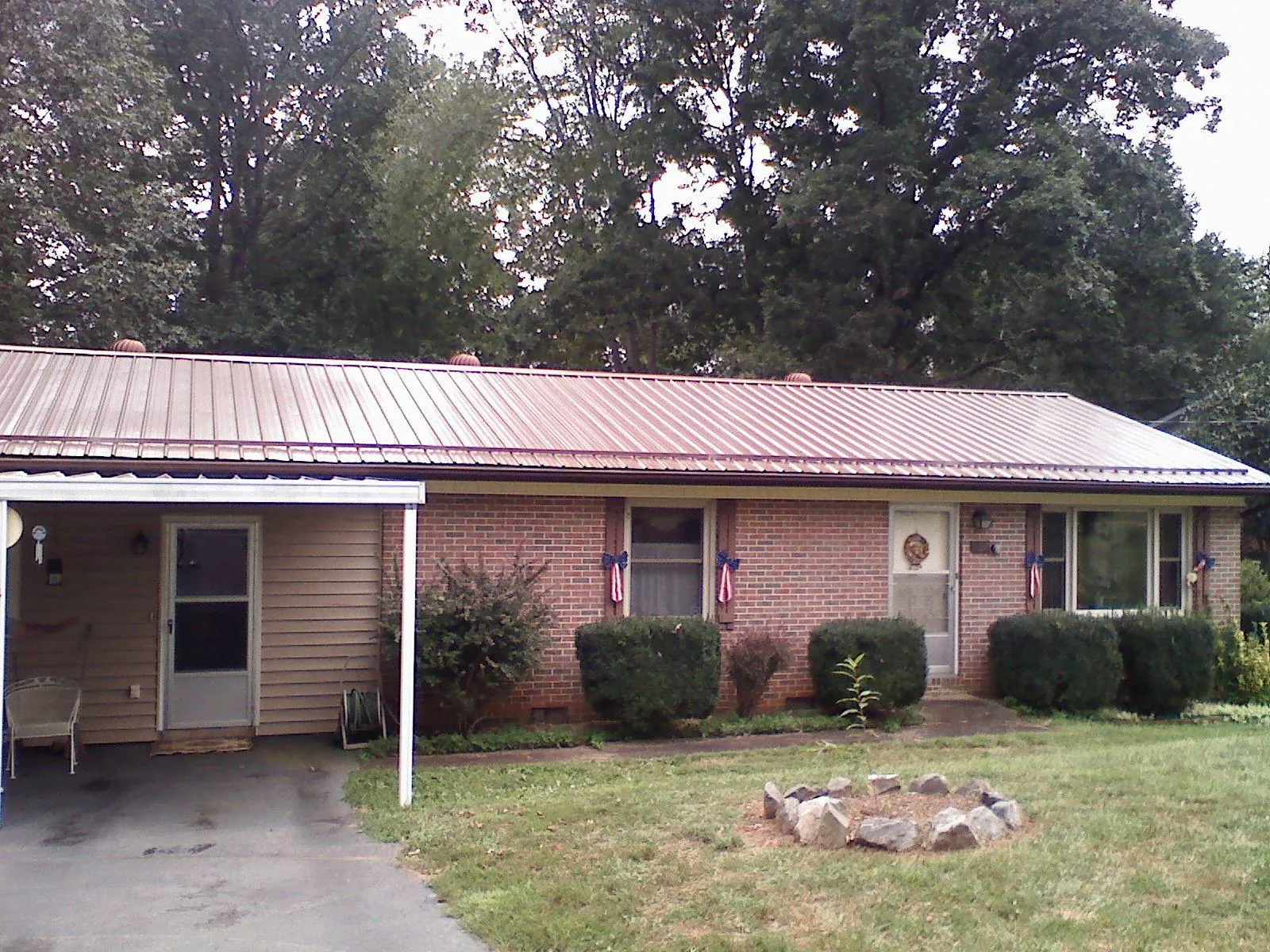 Bronze metal roof and carport on a brick ranch home — Roof Repair work by our crew in Bradford